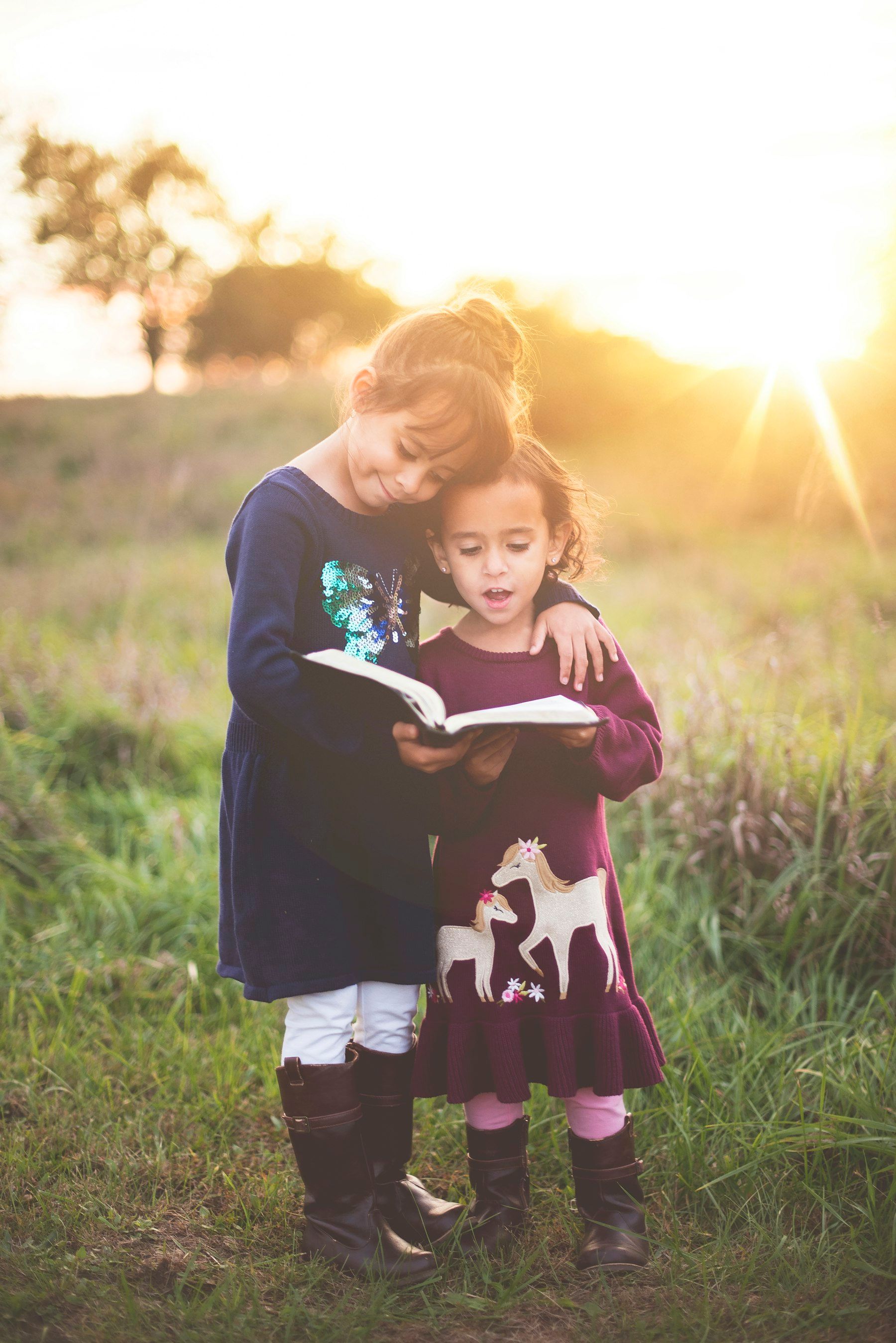 A girl reading to her little sister